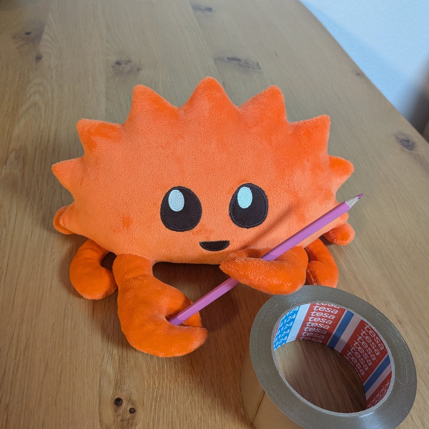 Rust Ferris with a pink pencil